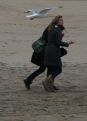 Girls at beach with potatoe chips menaced by pigeons